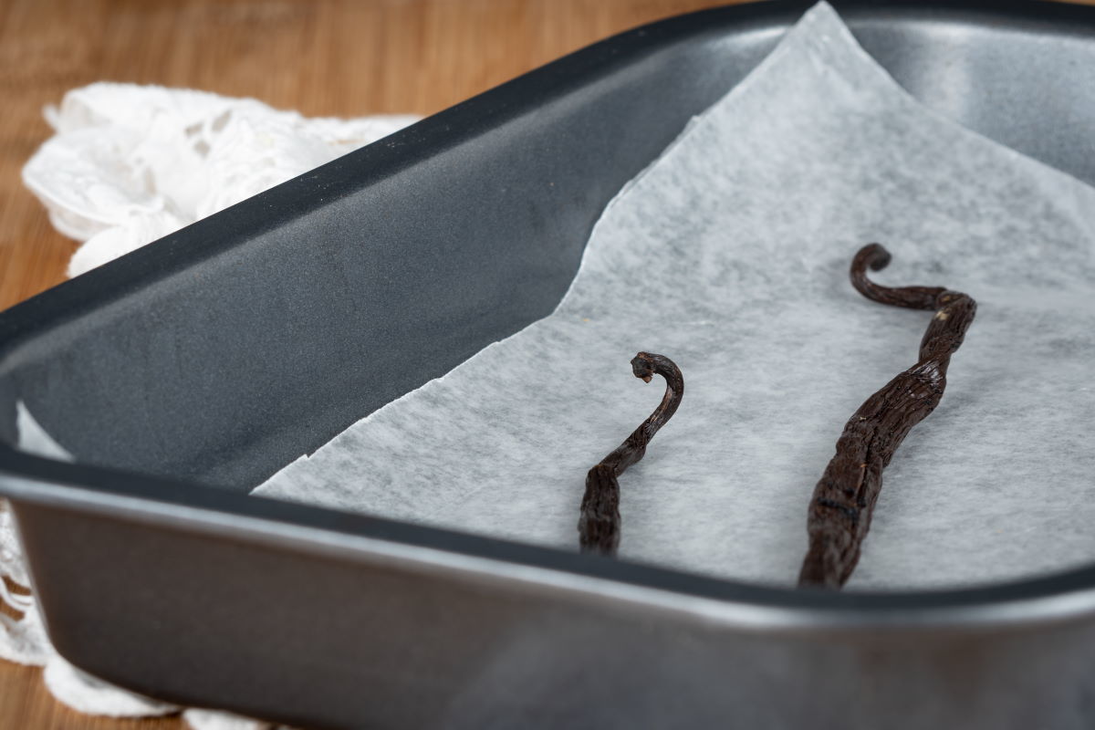 Vanilla beans pods sitting in a baking tray.