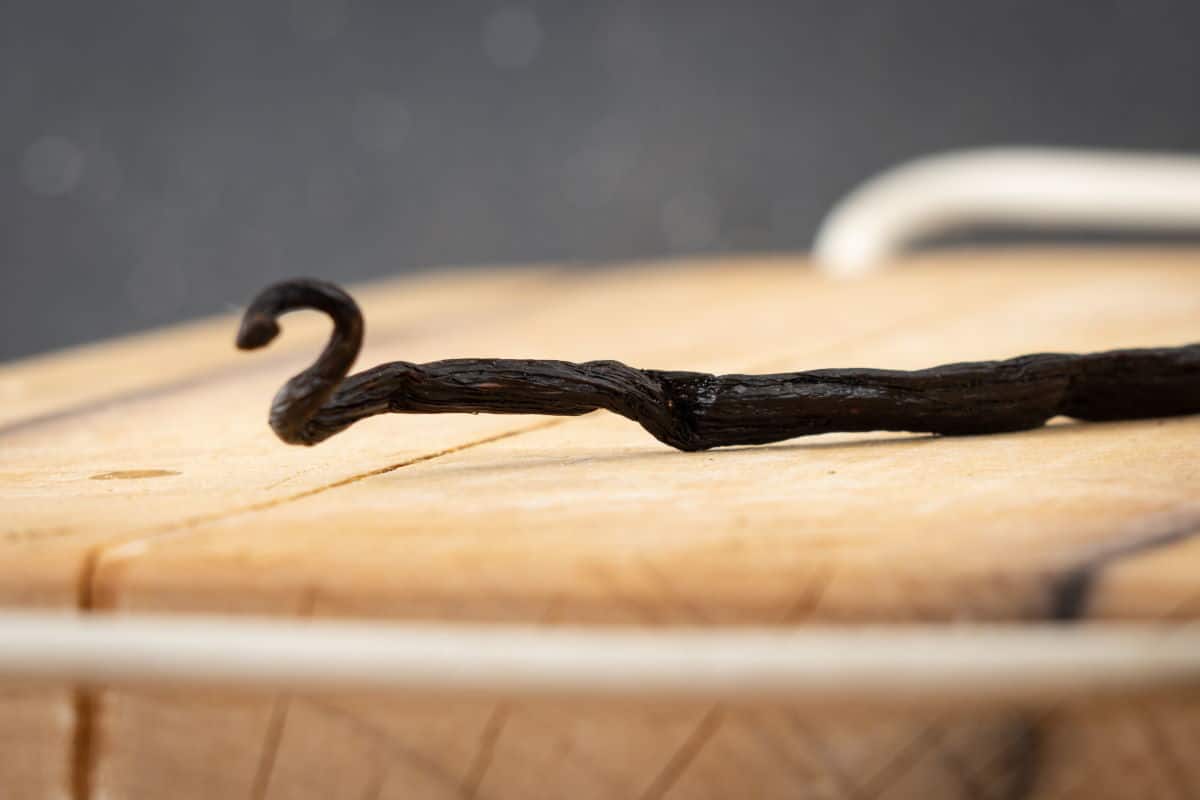 Vanilla bean pod on a cutting board.