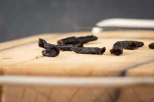 Chopped vanilla bean pods on a cutting board.