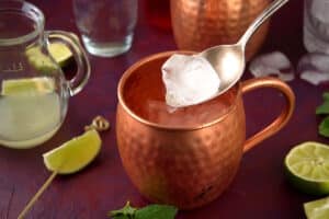 Ice in copper Moscow Mule mug with a spoon.