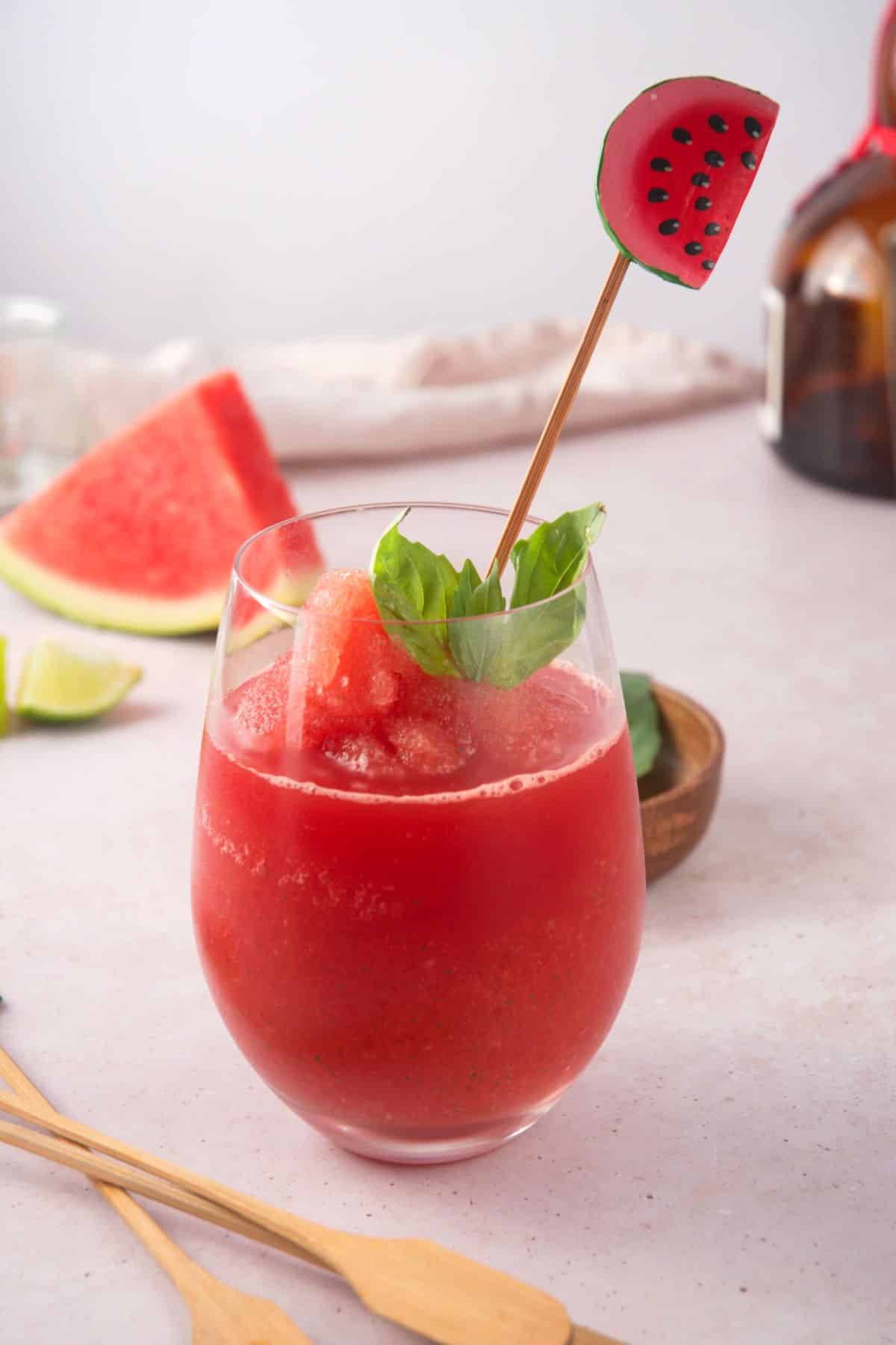 Watermelon basil cocktail in wine glass with a watermelon stir stick.