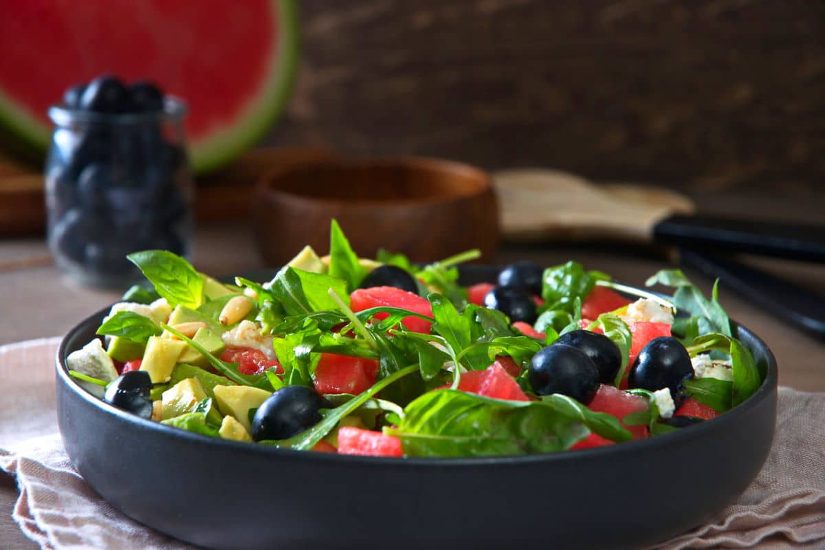 Watermelon salad in a black salad bowl, front view.