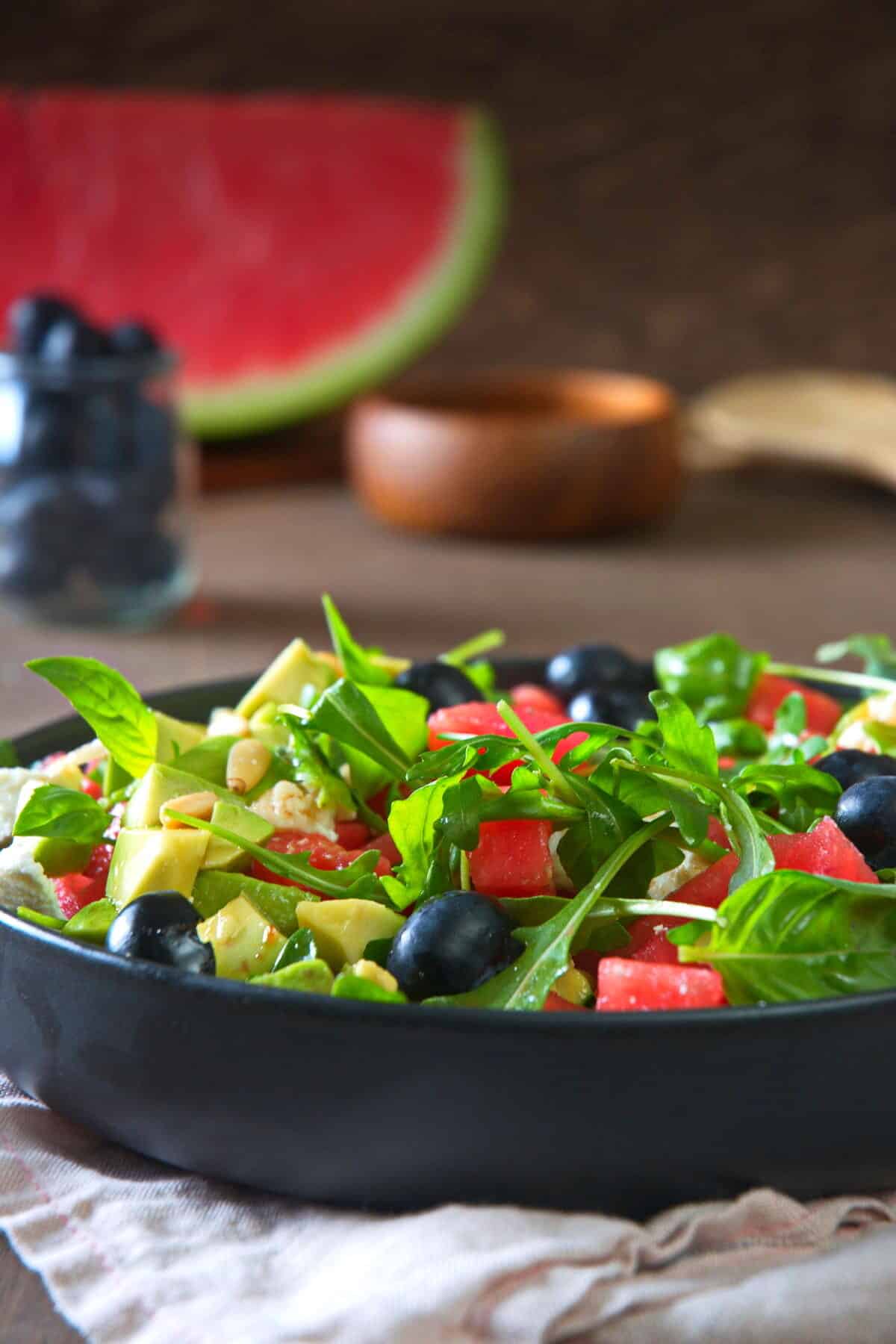 Watermelon salad in a black salad bowl, front view.
