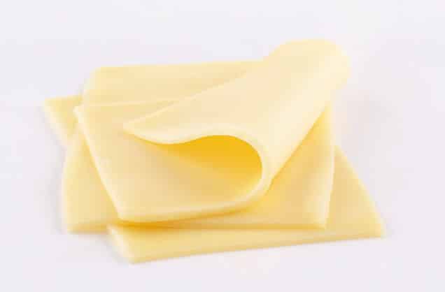 White cheddar cheese slices on white background.
