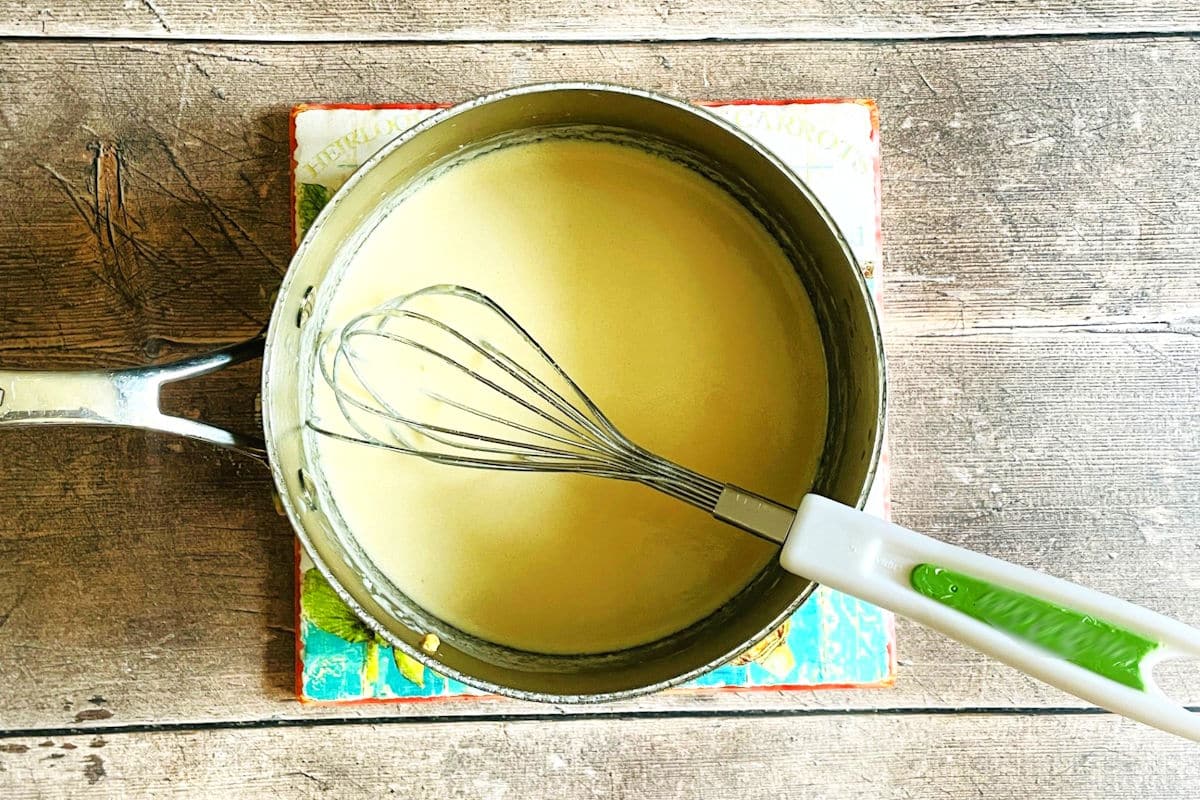 Milk and roux mixture in saucepan.