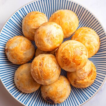 Puff pastry chicken balls on blue and white plate.