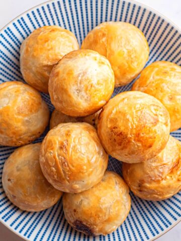 Puff pastry chicken balls on blue and white plate.
