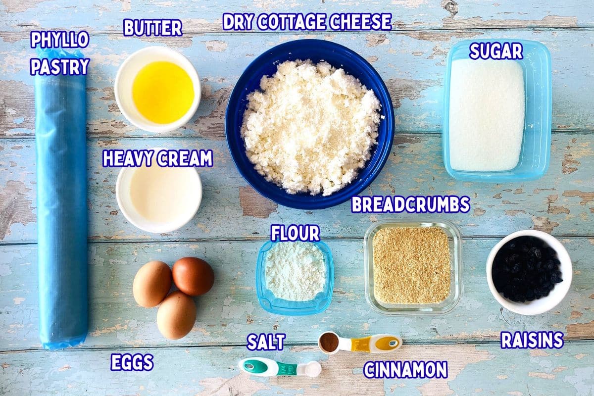 Cheese strudel ingredients prepped and labeled on blue wooden background.