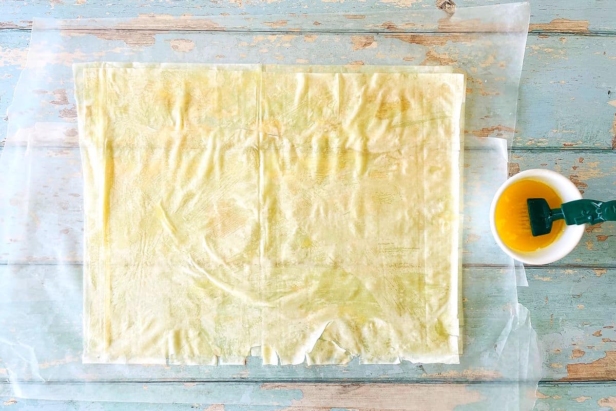 Phyllo pastry sheets greased with melted butter.
