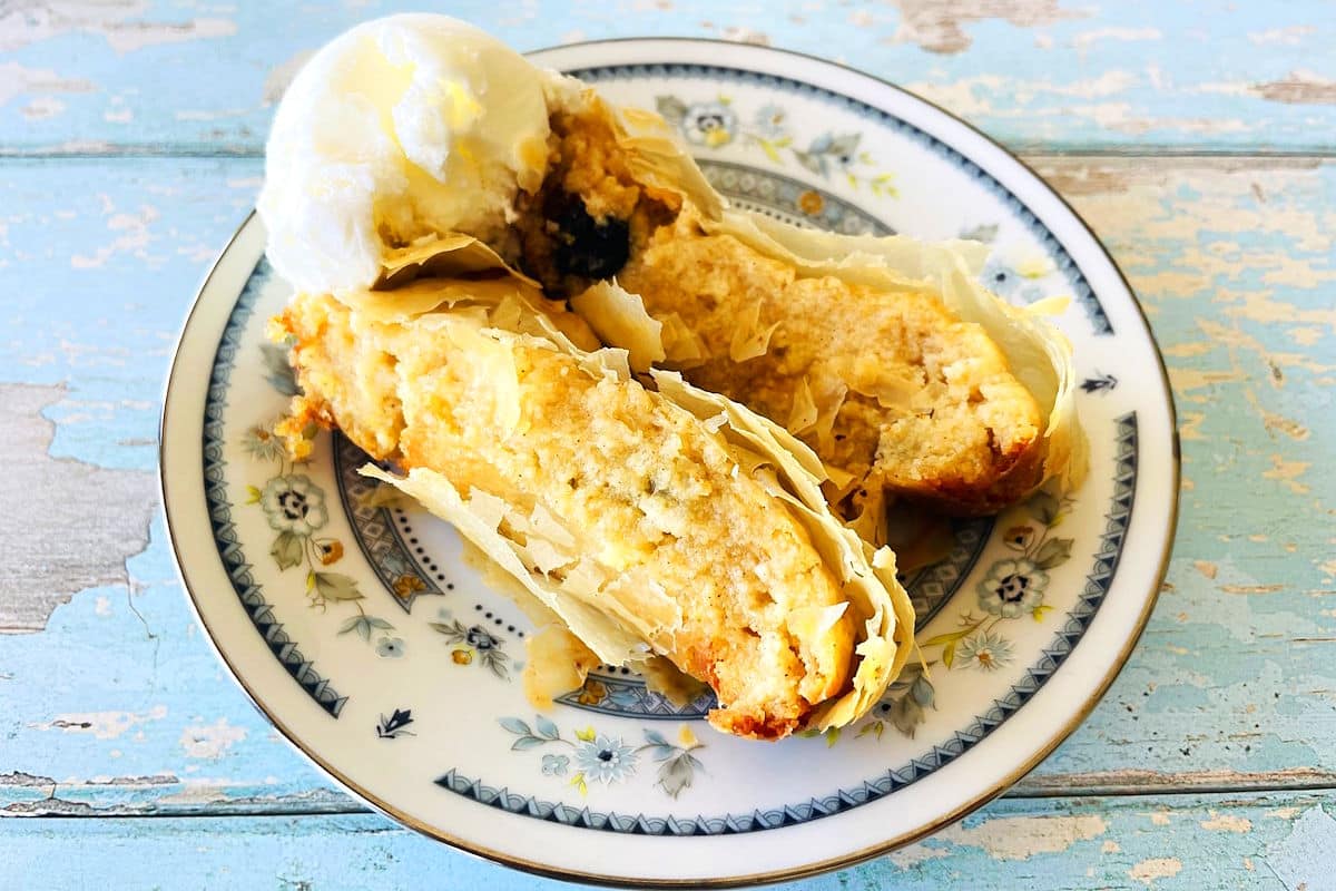 Slices of cheese strudel on plate with vanilla ice cream.