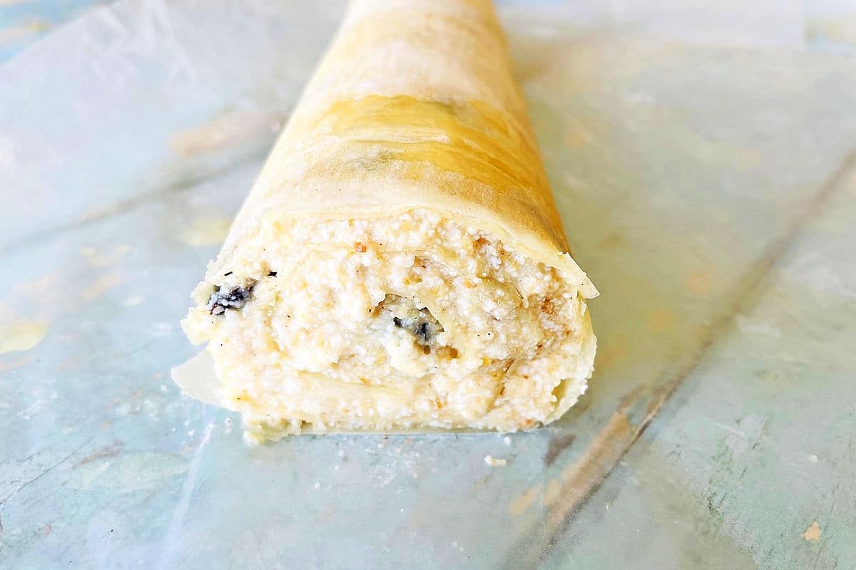 Raw cheese strudel cut open to expose the center swirl.