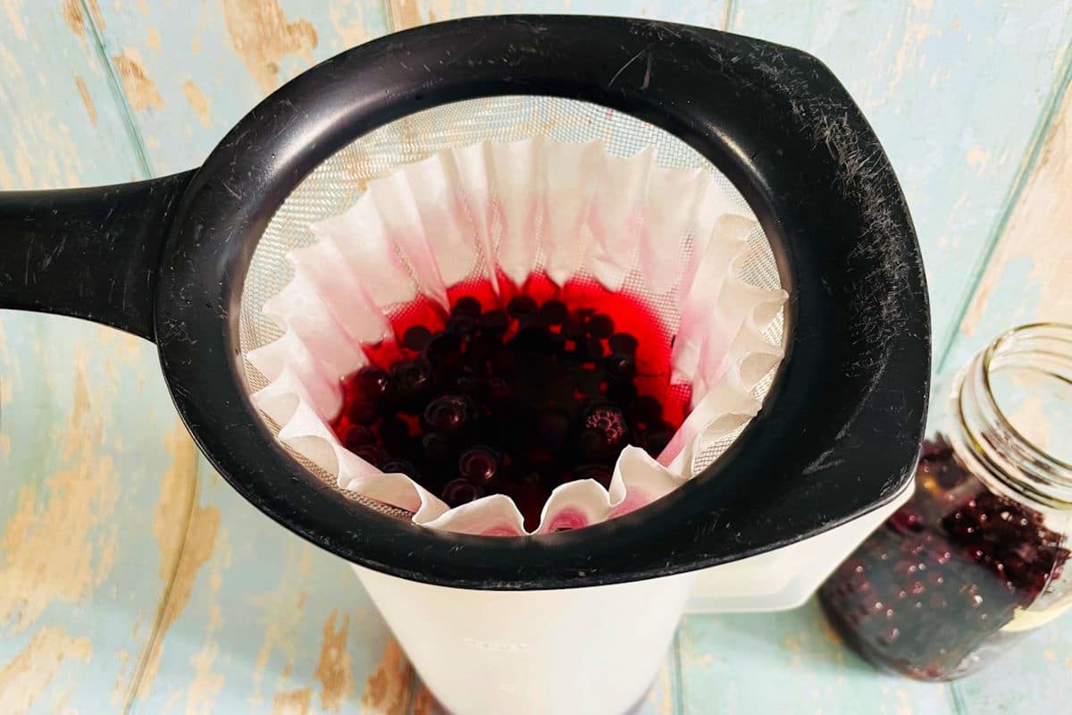 Chokecherry liqueur straining through coffee filter.