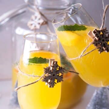 Christmas punch in champagne glasses with wooden snowflake decorations.