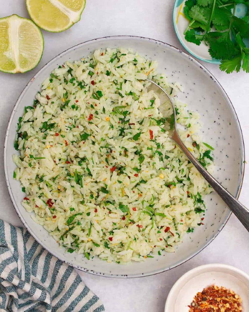 Cilantro rice on rustic white plate. Lime halves on the side.