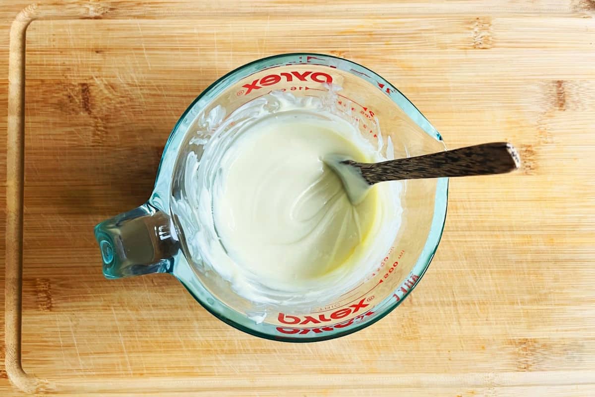 White chocolate cake pop coating in measuring glass.