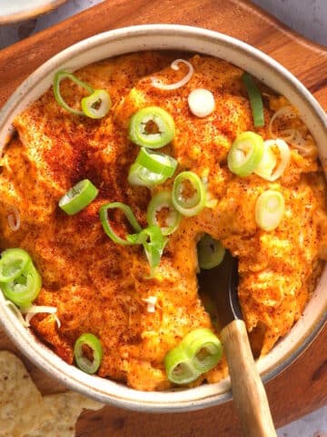 Buffalo chicken dip with green onions in serving dish.