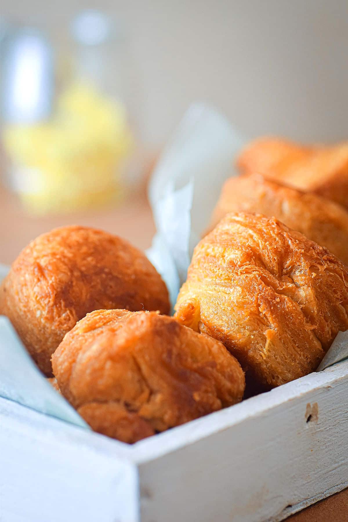 Golden biscuits in white, parchment-lined serving tray.