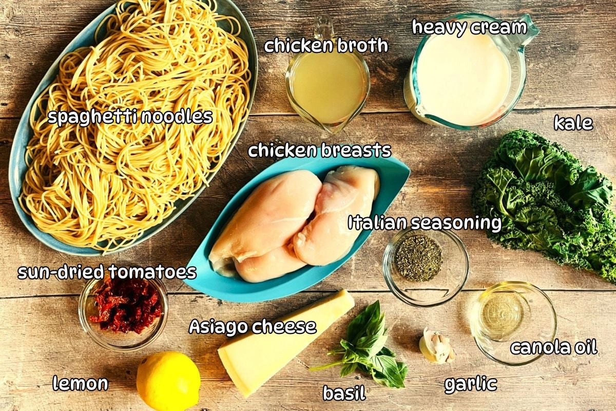 Creamy Tuscan chicken ingredients labeled on wooden background.
