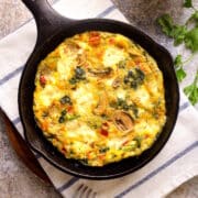 Electric skillet frittata in pan on kitchen towel.