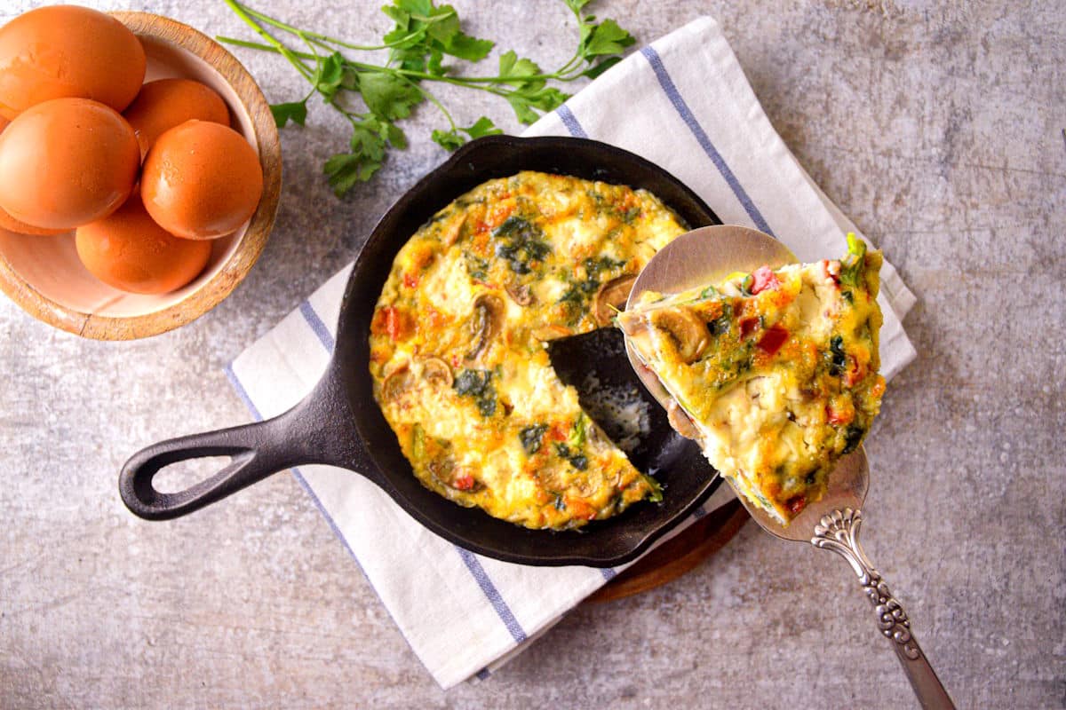 Electric skillet frittata in pan and on serving utensil.