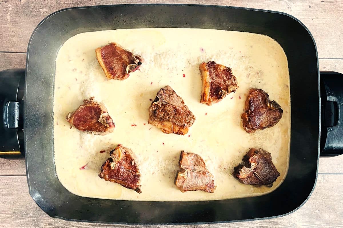 Lamb chops and cream sauce in electric skillet.