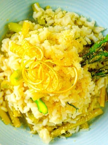 Risotto in bowl with asparagus and lemon zest.
