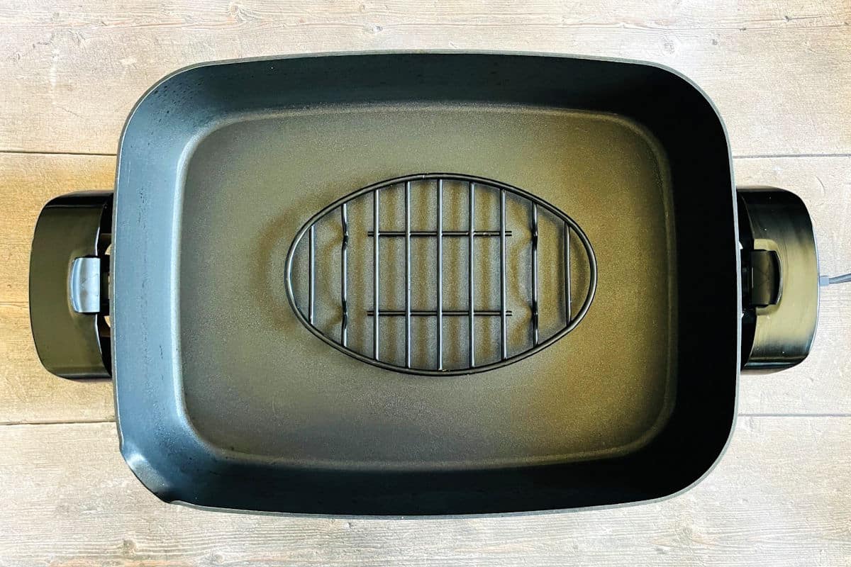 Small baking rack inside of an electric skillet.