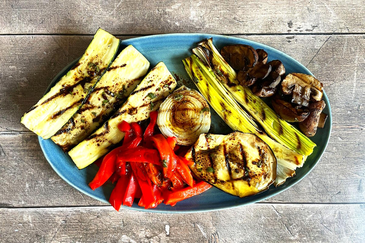 Escalivada vegetables arranged on blue serving dish.