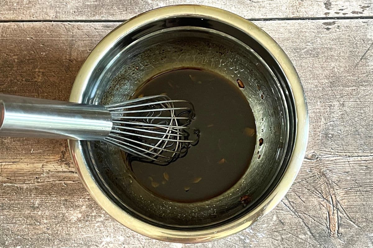 Bowl of escalivada dressing with whisk.