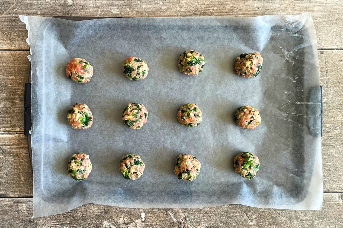 Raw turkey meatballs on sheet pan.