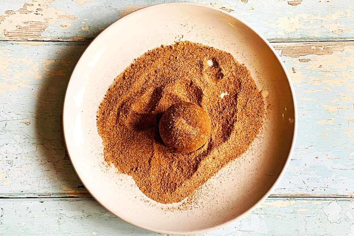 Gingerbread cake ball on plate of spiced sugar.