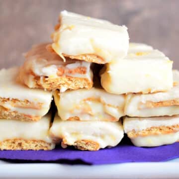 Graham wafer lemon bars stacked on purple napkin.