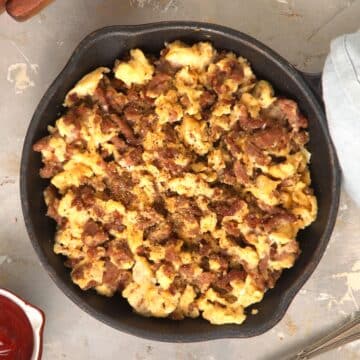 Hamburger scrambled eggs in cast iron pan.