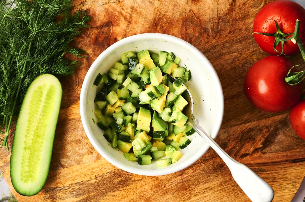 Diced cucumber and avocado in bowl.