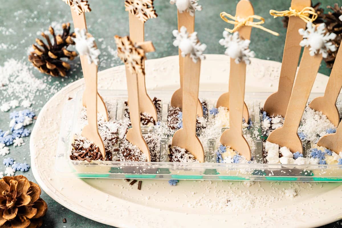 Spoons placed into chocolate filled ice cube tray.