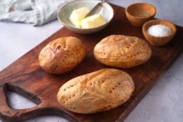 Baked potatoes on wooden board.