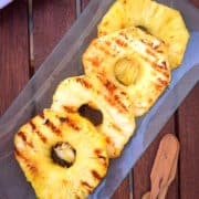 Grilled pineapple rings on serving dish.