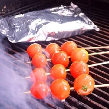 Skewered and foil-pack tomatoes on grill.