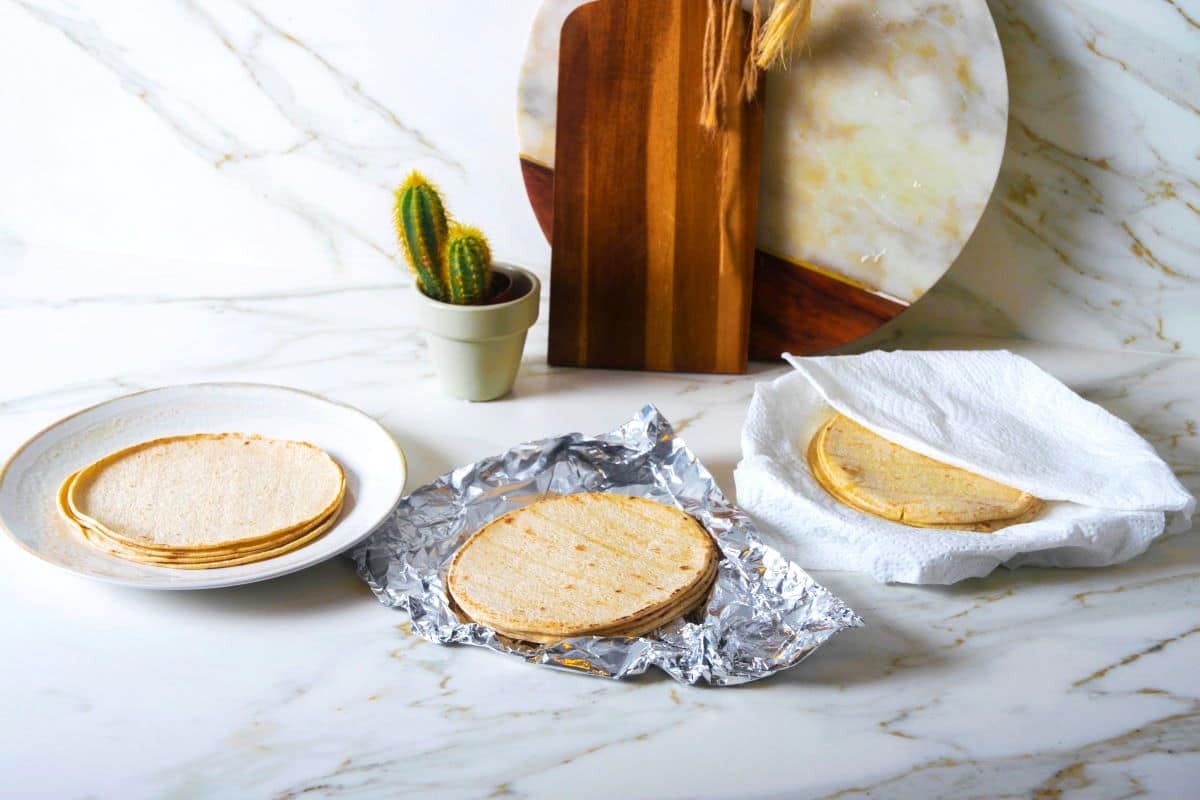 Corn tortillas in multiple stacks on marble countertop.