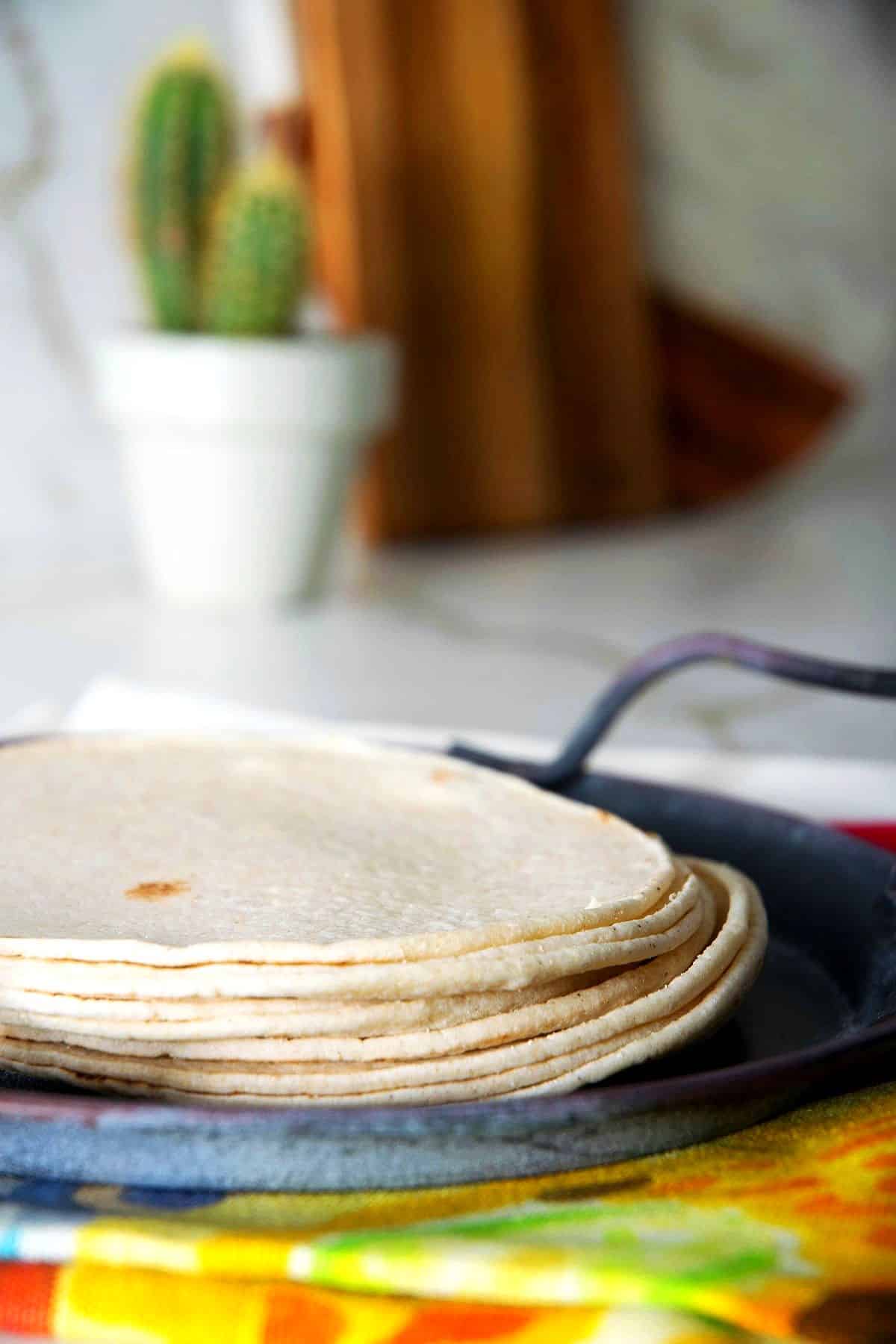 Corn tortillas stacked on serving tray.