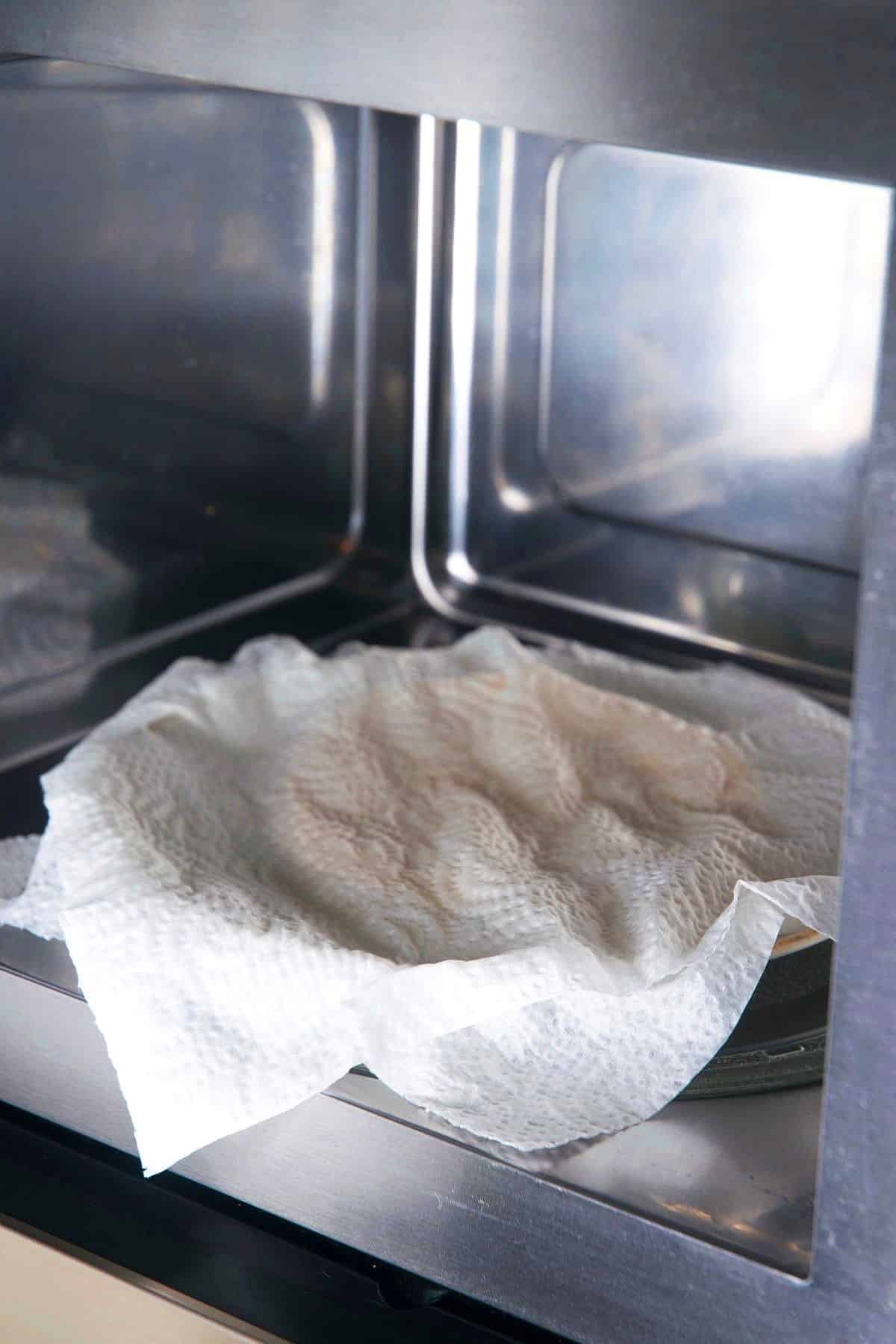 Moist paper towel covered corn tortillas in microwave.