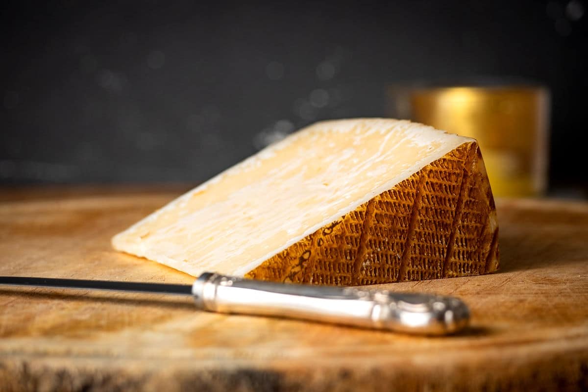 Manchego cheese on wooden board.