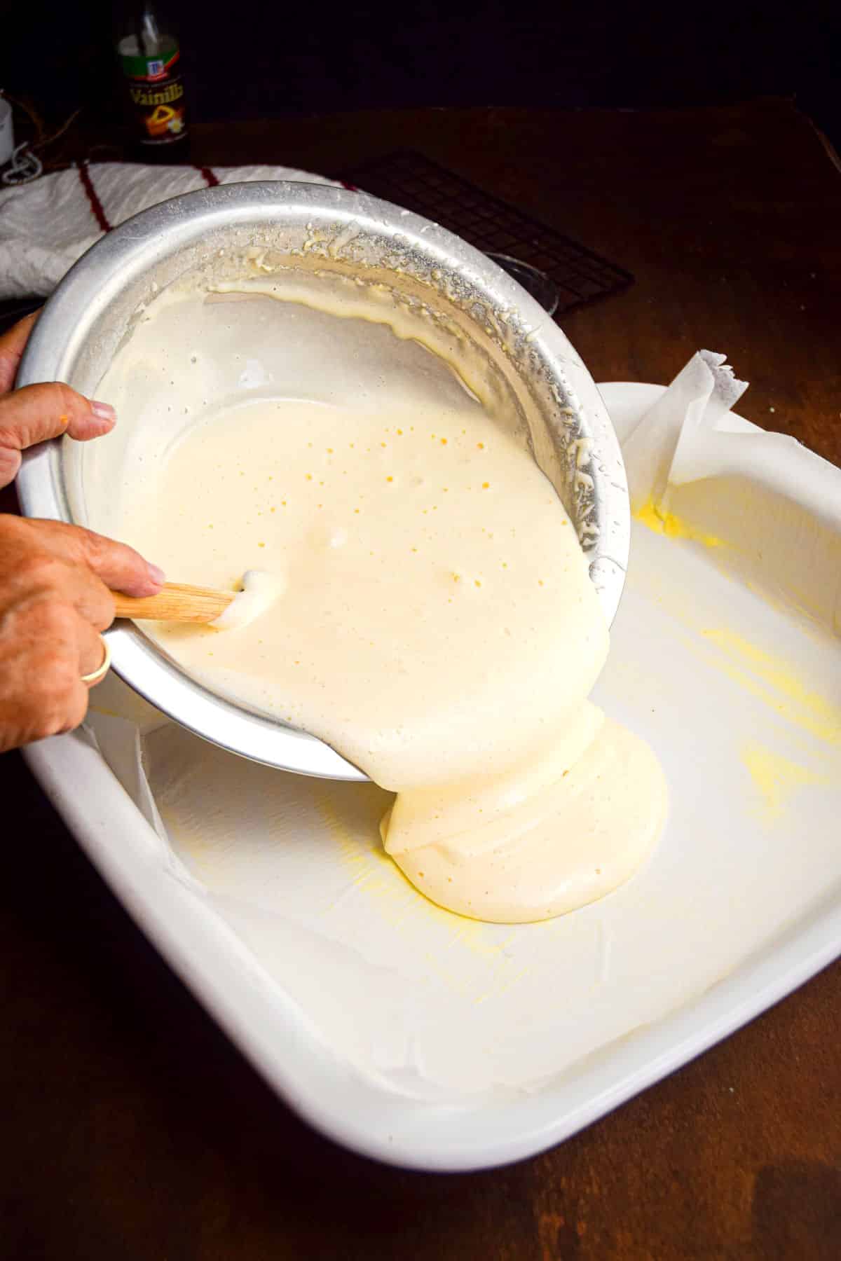 Jelly roll batter getting poured into jelly roll cake pan.