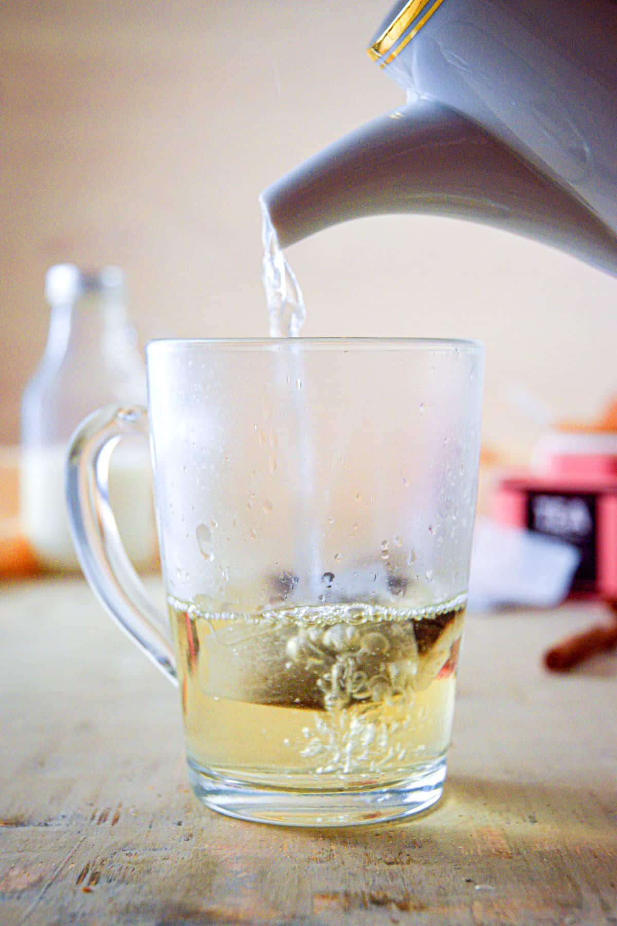 A clear glass mug with hot water and Earl Grey tea bag.