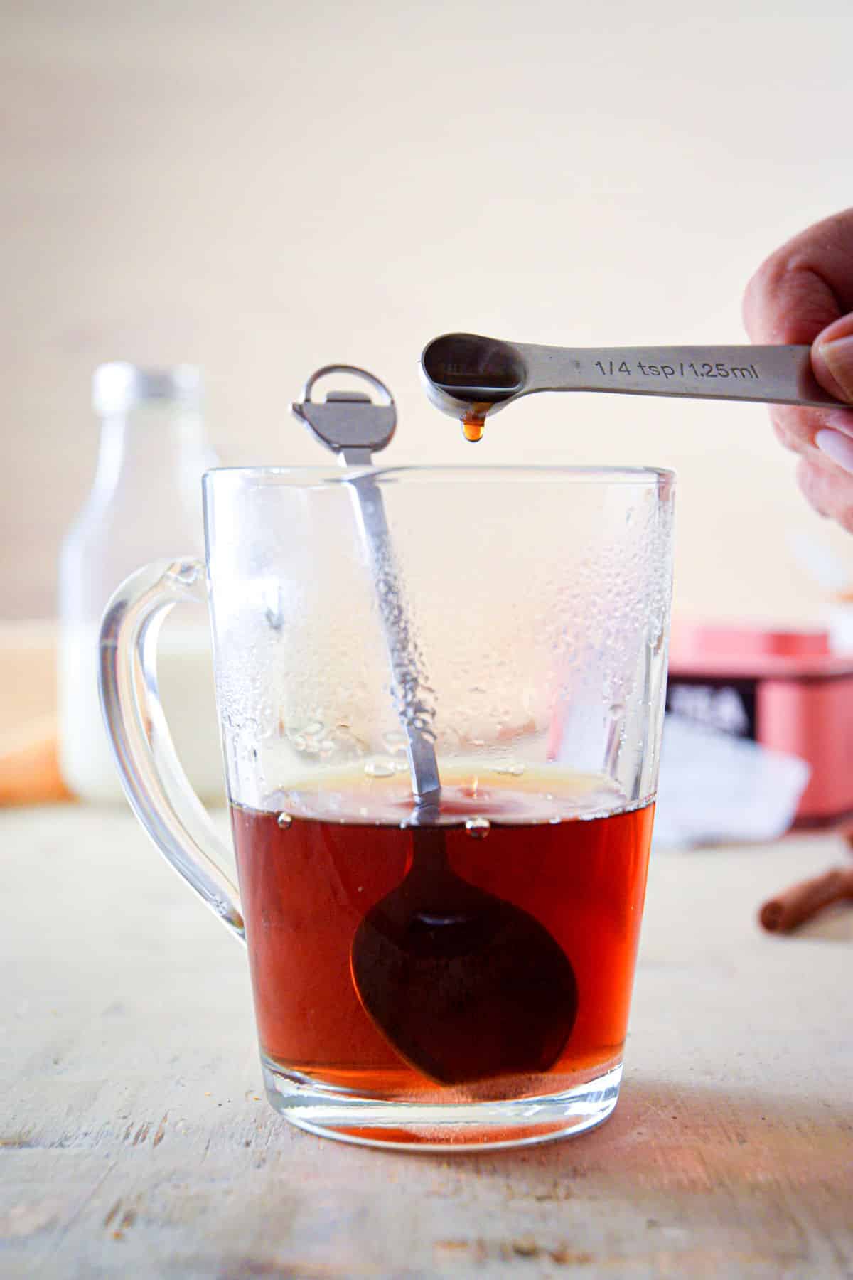 A clear glass mug with Earl Grey tea and vanilla extract.