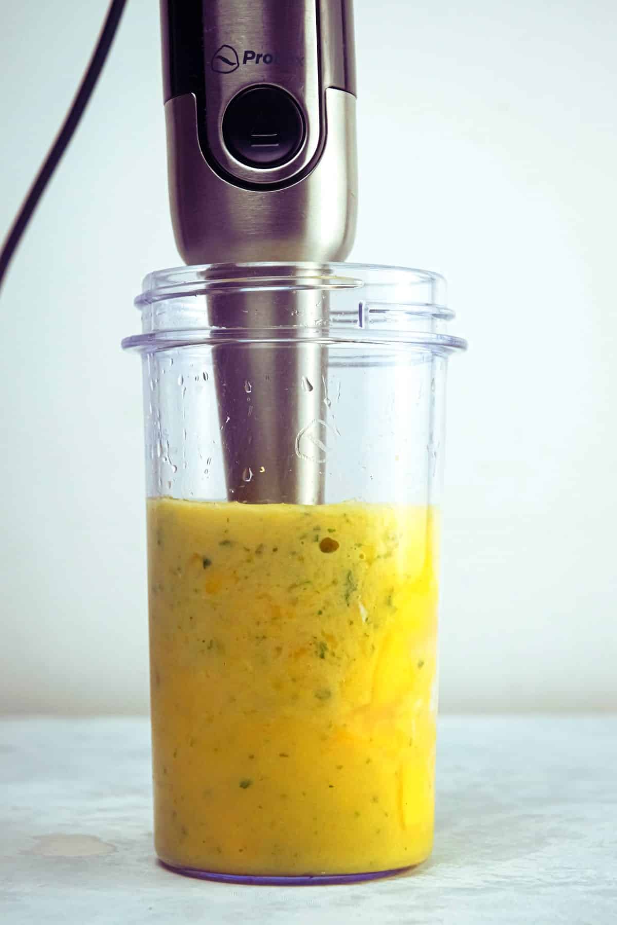 Mango pineapple smoothie in a blender jar.