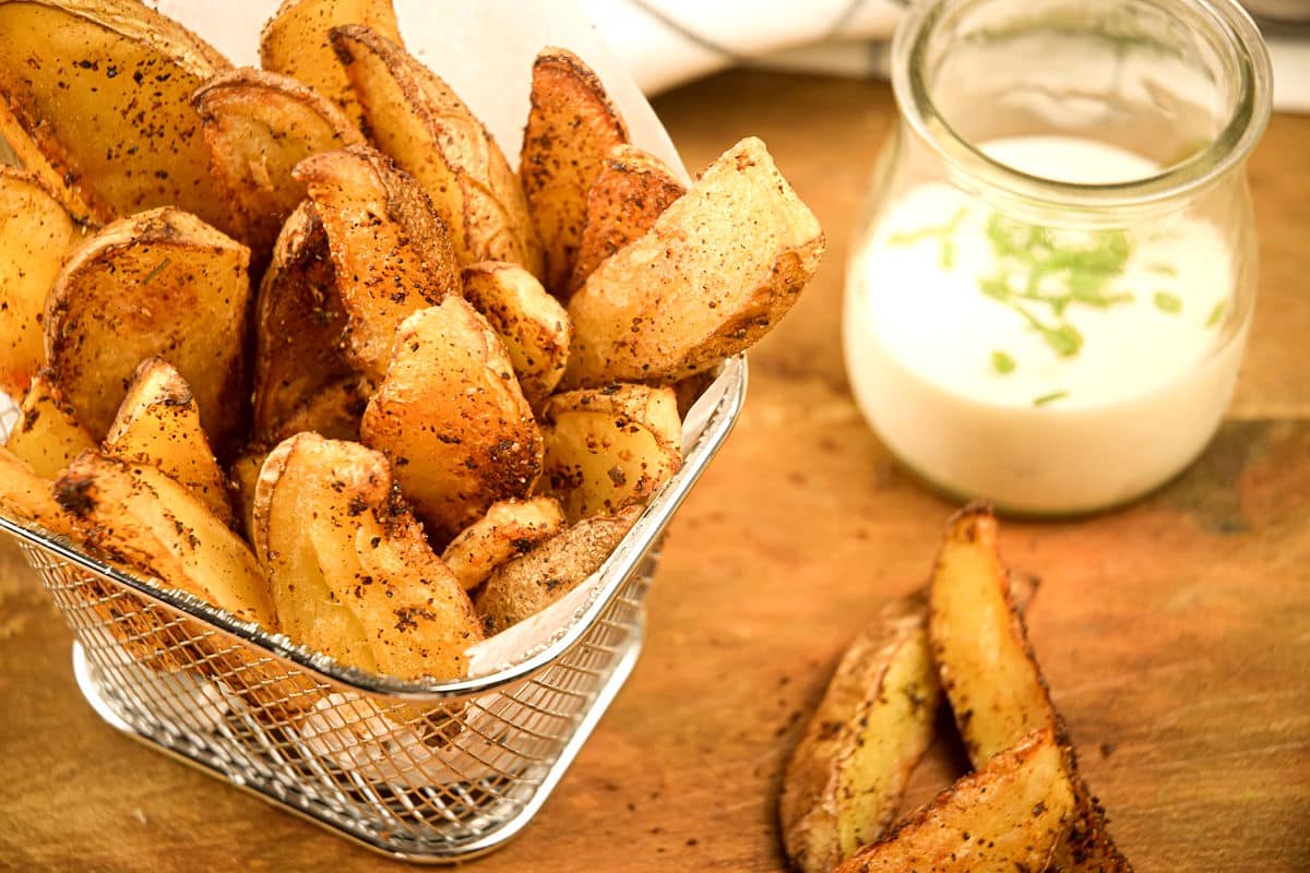 Cajun fries in basket with ranch dip on the side.