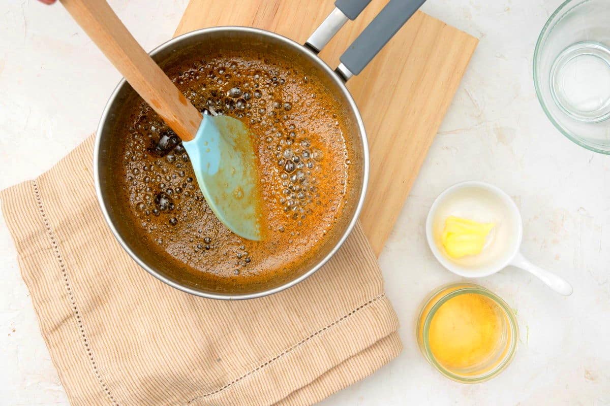 Caramel syrup in pot with spatula.