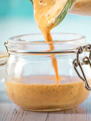 Chipotle sauce pouring from blender into jar.