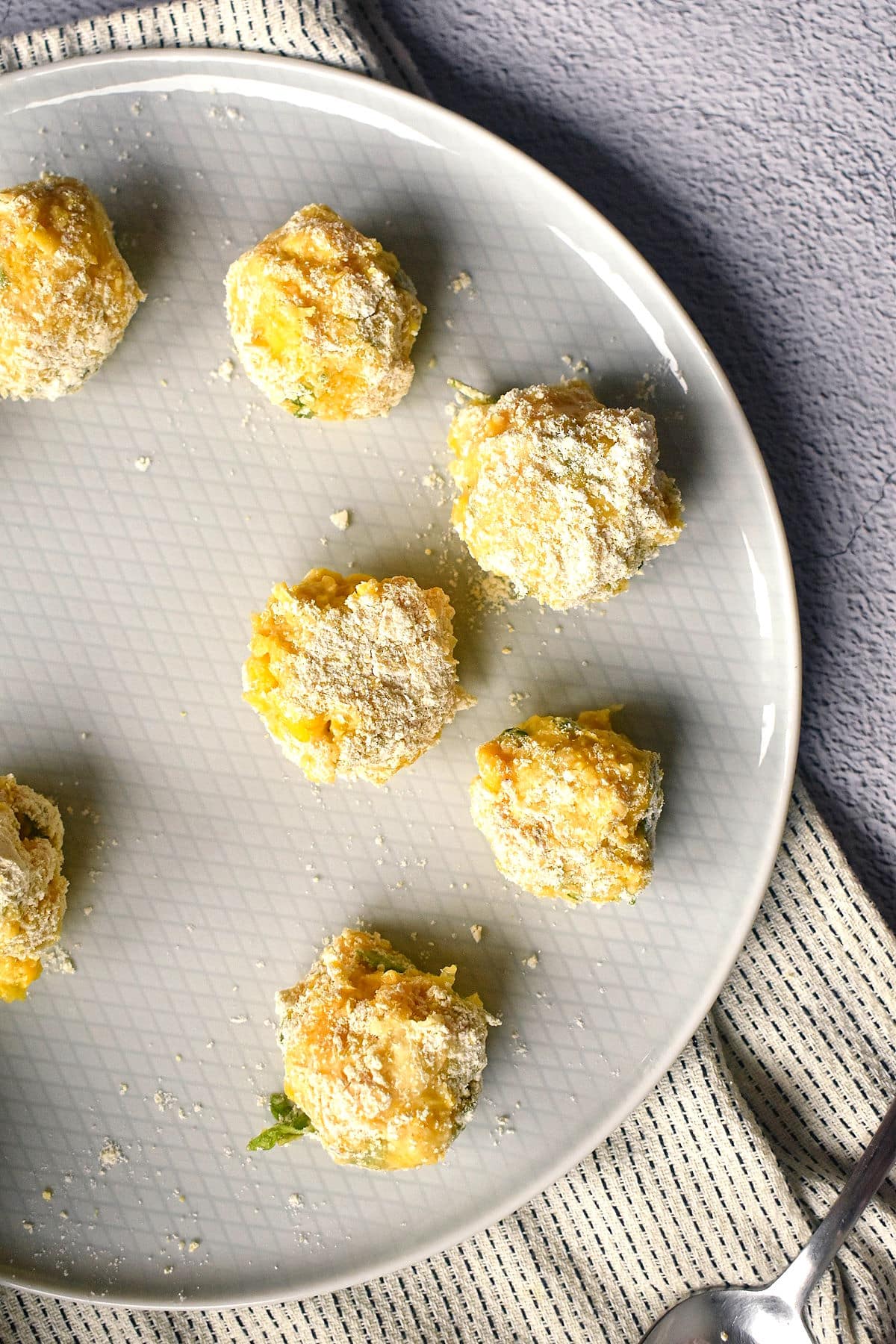 Raw corn nuggets with flour coating on plate.